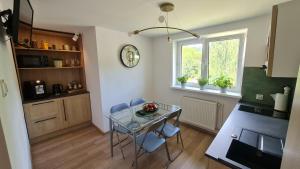 a kitchen with a glass table and blue chairs at Szumią Płaziny in Muszyna