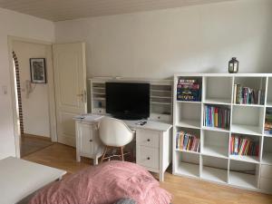 a bedroom with a desk with a television and a book shelf at Fewo Itzehoe in Itzehoe