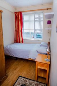 a small bedroom with a bed and a window at 2 Bed on The Main Street in Clogherhead