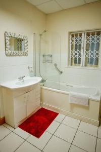 y baño con bañera, lavamanos y ducha. en 2 Bed on The Main Street en Clogherhead