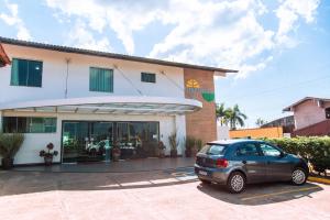 a car parked in a parking lot in front of a building at Hotel Equinocios Executive in Barcarena