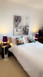 a bedroom with a large white bed with two lamps at COZYCOMFY LUXURY APARTMENT in London