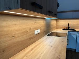 a kitchen with a counter and a wooden floor at Appartement NaMoll in Ausserfragant