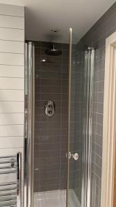 a shower with a glass door in a bathroom at COZYCOMFY LUXURY APARTMENT in London