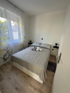 een slaapkamer met een bed met 2 kussens en een raam bij Apartment Roni in Zadar