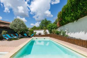 a swimming pool with two chairs and a fence at Le Place Neuve in Brullioles