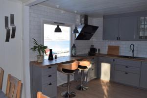 una cocina con encimera y taburetes. en Captains House, en Hamneide