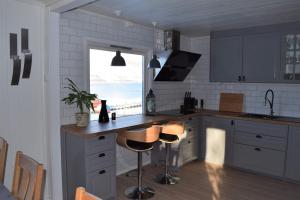 a kitchen with a counter and stools in it at Captains House in Hamneide
