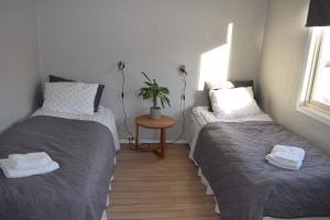 ein Schlafzimmer mit 2 Betten und einem Tisch mit einer Pflanze in der Unterkunft Captains House in Hamneide
