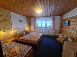 a hotel room with two beds and a window at Pension Popelka in Špindlerův Mlýn