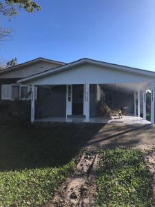 ein Haus mit einer Garage und einem Hund, der auf der Veranda sitzt in der Unterkunft Hospedaria Rural Recanto Verde dos Canyons in Praia Grande