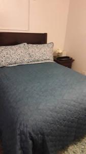 a bed with a blue comforter and a pillow at Catherine's Retreat in Nazareth