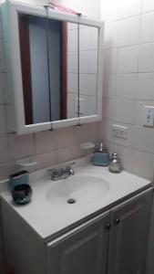 La salle de bains est pourvue d'un lavabo blanc et d'un miroir. dans l'établissement Catherine's Retreat, à Nazareth