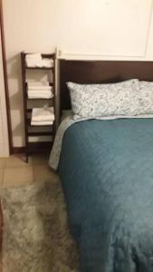 a bedroom with a blue bed and a shelf with towels at Catherine's Retreat in Nazareth