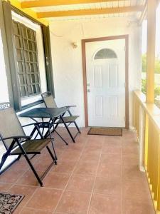 una veranda con sedie, tavolo e porta di Catherine's Retreat a Nazareth