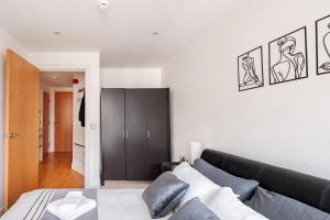 a bedroom with a bed and a black cabinet at Cozy Apt Near Central Leeds in Hunslet