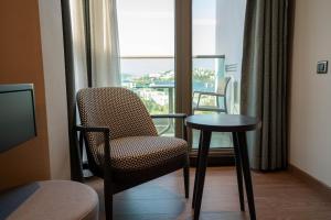 a room with a chair and a table and a window at Palm Hills Bodrum Hotel in Bodrum City