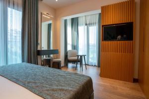 a hotel room with a bed and a flat screen tv at Palm Hills Bodrum Hotel in Bodrum City