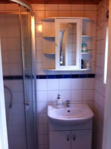 a bathroom with a sink and a shower at Cozy and Private 3-Bed House with bath Roslagen in Herräng +20 photos