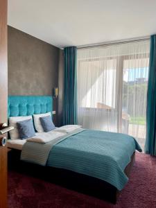 una camera da letto con letto con testiera blu e finestra di Luksusowy Apartament Klif a Władysławowo