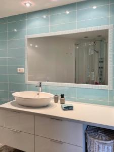 bagno con lavandino e grande specchio di Luksusowy Apartament Klif a Władysławowo