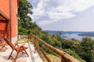 a balcony with two wooden chairs and a view of a lake at Casa Belvedere Egro - tiny house in Cesara