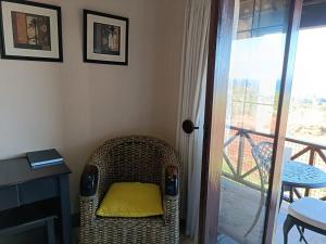 - une chaise en osier avec un oreiller jaune dans l'établissement Ocean View Villas F16 Port Edward, à Port Edward
