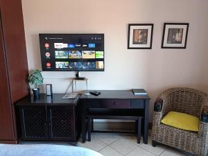 a desk with a computer and a tv on a wall at Ocean View Villas F16 Port Edward in Port Edward