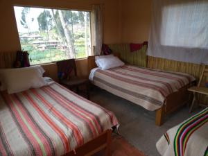a room with two beds and a window at Taquile Sumaq Wasi - Casa de Felipe e Ines in Huillanopampa