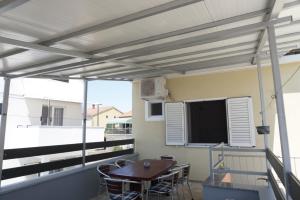 a patio with a table and a tv on a balcony at Apartmani Skledar in Vodice