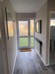 an empty room with a large window and a door at The Bungalow in Dersingham