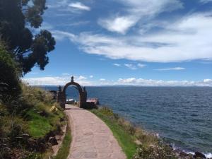 un camino junto a un cuerpo de agua en Taquile Sumaq Wasi - Casa de Felipe e Ines, en Huillanopampa