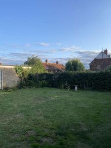 a yard with a grassy yard with houses in the background at The Bungalow in Dersingham