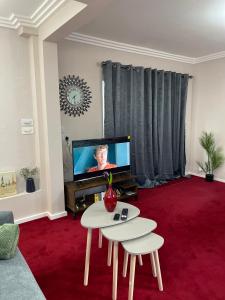 a living room with a table and a tv at Luxurious and Elegant Homestay in Kent in Wrotham