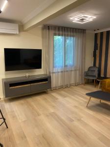 a living room with a flat screen tv on a wall at G apartment in Plovdiv