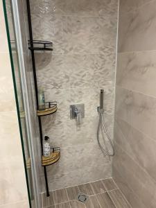 a bathroom with a shower with two shelves in it at G apartment in Plovdiv