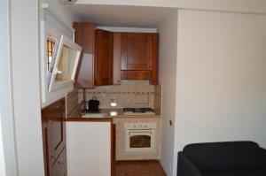 a small kitchen with wooden cabinets and a stove at Domi - Appartamento Roma in Rome +15 photos