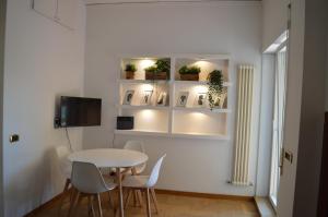a white dining room with a table and chairs at Domi - Appartamento Roma in Rome