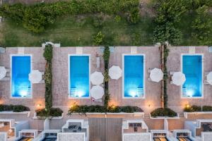 an overhead view of the pool at a resort with blue water at RITA MARE seafront villas in Gennadi