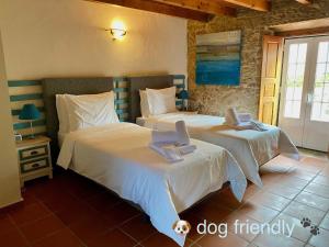 een slaapkamer met 2 bedden met een hond erop bij Vida-Vi, Country House and B&B in Santa Catarina