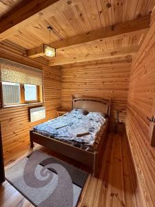 a bedroom with a bed in a wooden cabin at Сієста in Svityazʼ