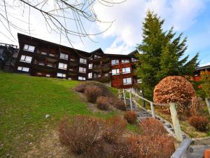 a large building on top of a green hill at Appartement Les Gets, 2 pièces, 5 personnes - FR-1-685-23 in Les Gets