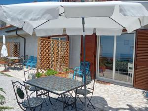 a table and chairs under an umbrella on a patio at La Terrazza Del Duca in Marina di Camerota