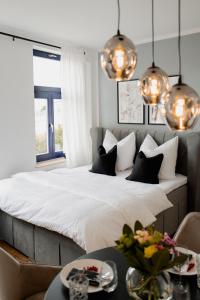 1 dormitorio con 1 cama grande con almohadas blancas y negras en Designoase für 3 mit Blick auf den Wismarer Hafen, en Wismar