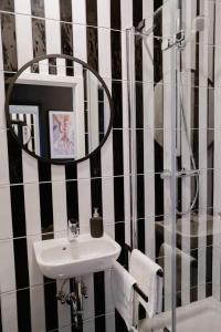 - czarno-białą łazienkę z umywalką i lustrem w obiekcie Designoase für 3 mit Blick auf den Wismarer Hafen w mieście Wismar