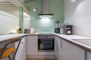 a kitchen with white cabinets and a stove top oven at Appartement de caractère 6 pers -hyper centre in Lyon