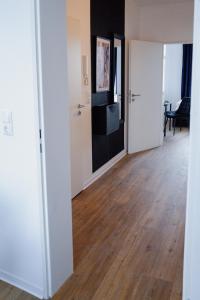an empty room with a hallway with wooden floors at Designoase für 3 mit Blick auf den Wismarer Hafen in Wismar