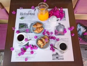 a table with a tray of food and coffee and flowers at Alkifron Hotel in Kala Nera