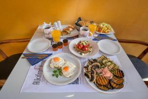 a table with plates of food and drinks on it at Alkifron Hotel in Kala Nera