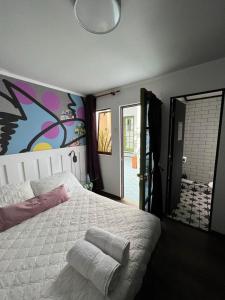 hotel velero cavancha في إكيكي: غرفة نوم بسرير كبير عليها لوحة على الحائط